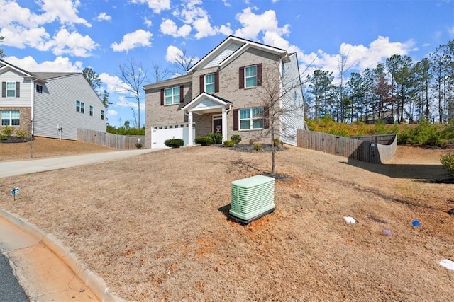 view of front of home with driveway, an attached garage, and fence