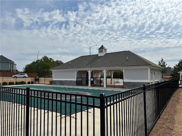 community pool featuring fence and a patio