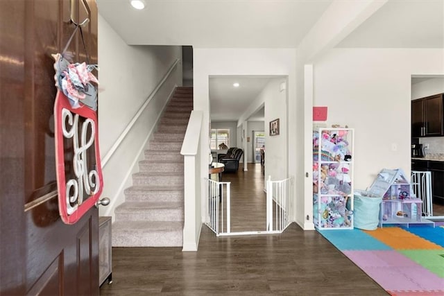 foyer entrance with stairway, wood finished floors, and recessed lighting