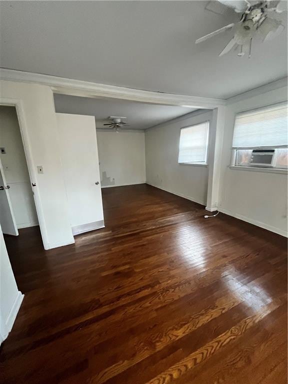 unfurnished room with cooling unit, wood finished floors, a ceiling fan, baseboards, and crown molding