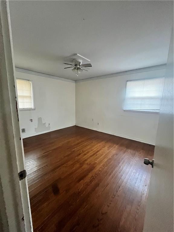 empty room with ceiling fan, ornamental molding, and dark wood-style flooring