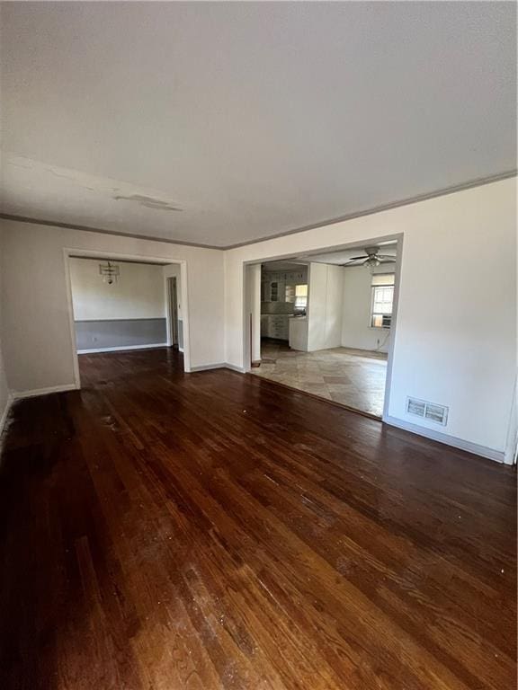 unfurnished living room featuring hardwood / wood-style flooring, ceiling fan, visible vents, and baseboards