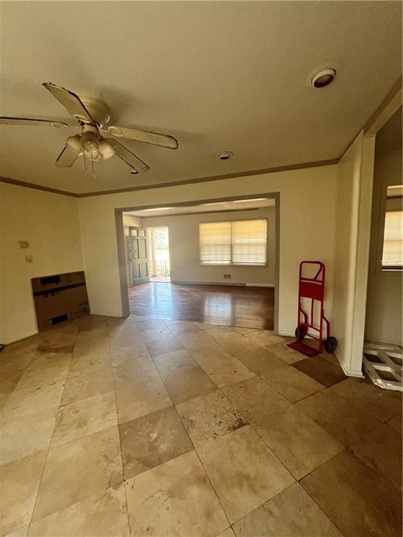 unfurnished living room featuring ornamental molding and a ceiling fan