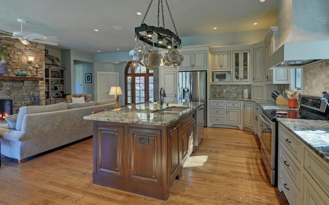 126 Jenkins Cir, Lakemont, GA 30552 - kitchen with stainless steel appliances, wall chimney exhaust hood, cream cabinets, light stone countertops, and ceiling fan