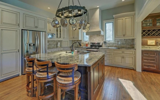 126 Jenkins Cir, Lakemont, GA 30552 - kitchen featuring appliances with stainless steel finishes, cream cabinetry, custom range hood, light stone counters, and a kitchen island with sink