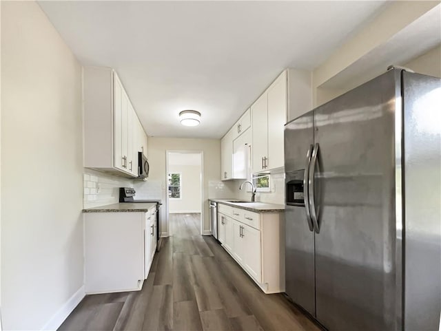 3811 Reynolds Rd, Douglasville, GA 30135 - kitchen featuring stainless steel appliances, tasteful backsplash, dark wood-style floors, white cabinets, and baseboards