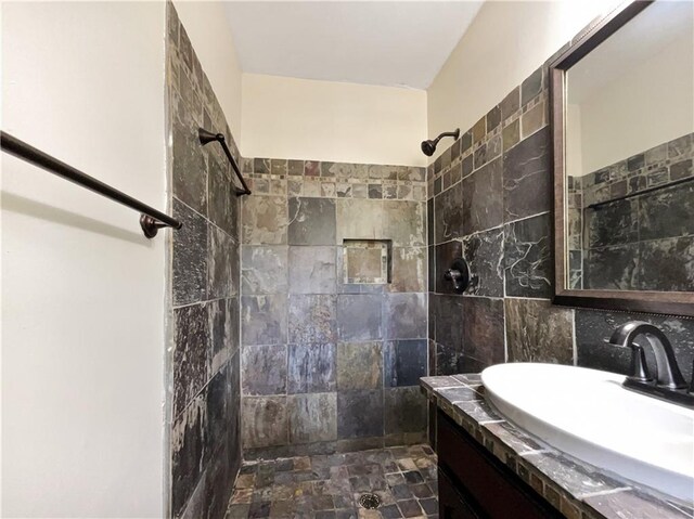 bathroom with vanity and a tile shower