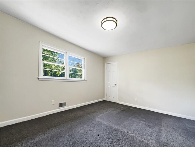 unfurnished room with dark colored carpet