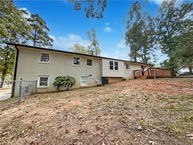 rear view of house featuring a deck and cooling unit