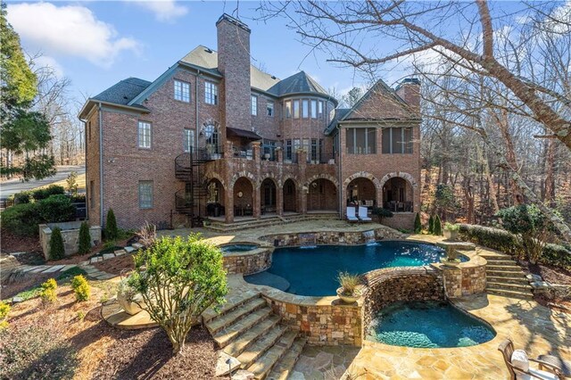 tudor house featuring covered porch, a front yard, and a garage