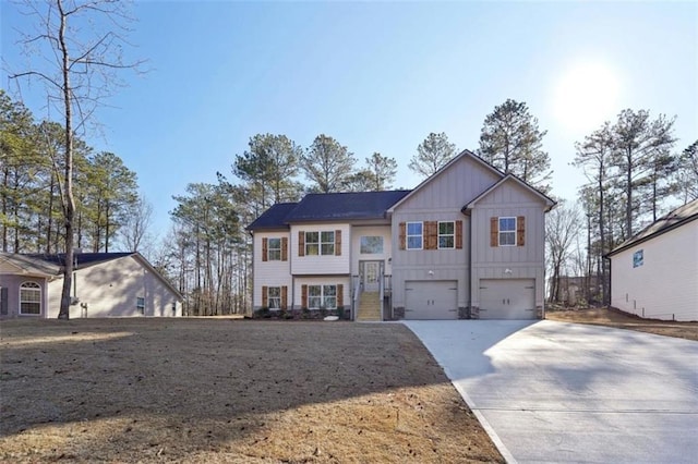 bi-level home featuring a garage, board and batten siding, and concrete driveway