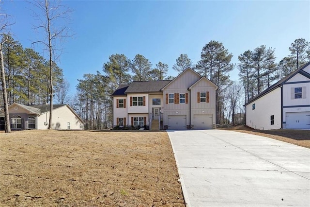 raised ranch featuring a garage, board and batten siding, and concrete driveway