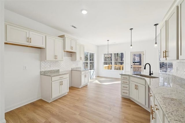 kitchen featuring a sink, light stone countertops, and tasteful backsplash