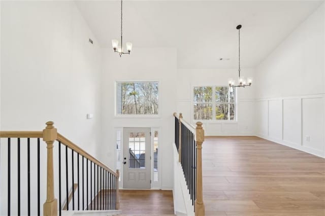 foyer featuring high vaulted ceiling, plenty of natural light, and a chandelier