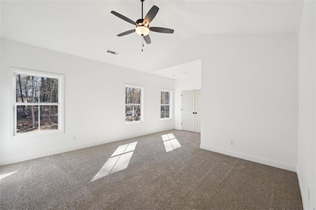 carpeted spare room featuring ceiling fan, visible vents, baseboards, and high vaulted ceiling