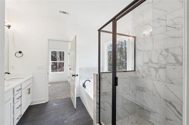 bathroom featuring a bath, visible vents, vanity, baseboards, and a marble finish shower