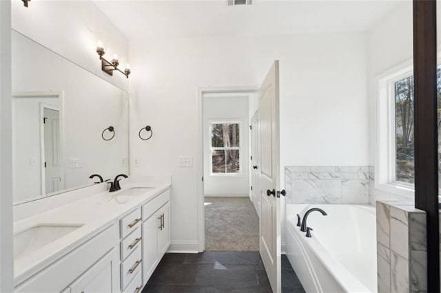 full bath featuring double vanity, a sink, a bath, and visible vents
