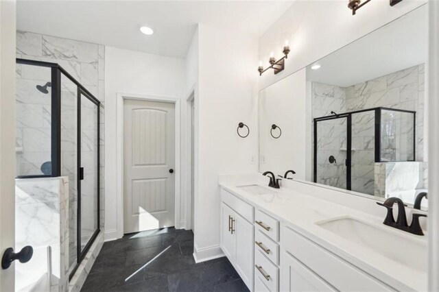 full bath with a sink, a marble finish shower, double vanity, and marble finish floor