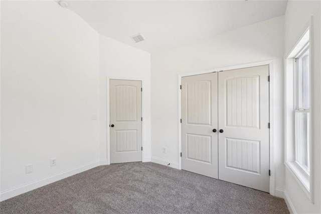 unfurnished bedroom featuring carpet floors, a closet, visible vents, and multiple windows