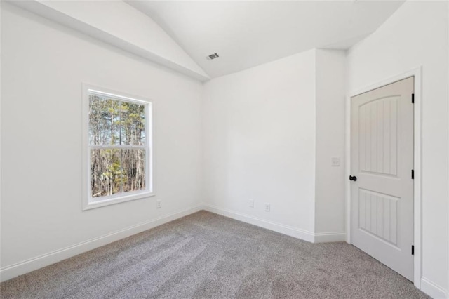 unfurnished room featuring baseboards, carpet, and vaulted ceiling