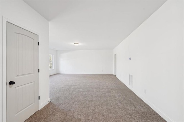 unfurnished room featuring baseboards and carpet