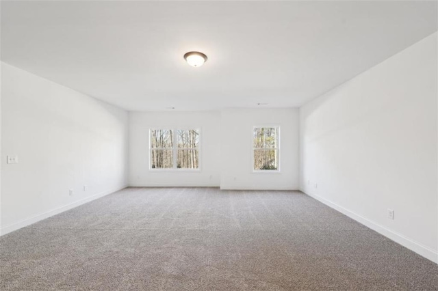 carpeted spare room featuring baseboards