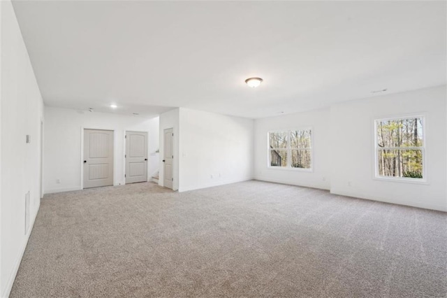 spare room with baseboards and light carpet