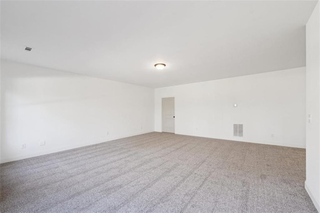 carpeted empty room featuring visible vents