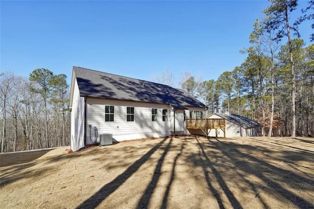rear view of house with central AC unit and a deck