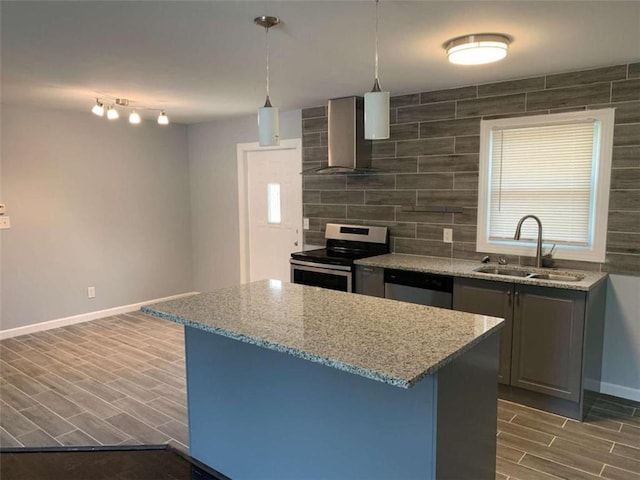 kitchen with sink, wall chimney exhaust hood, dark wood-type flooring, stainless steel appliances, and light stone counters