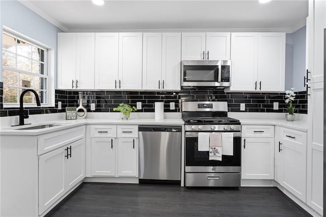 1931 Selwyn Dr, Decatur, GA 30035 - kitchen with appliances with stainless steel finishes, a sink, white cabinets, light countertops, and decorative backsplash