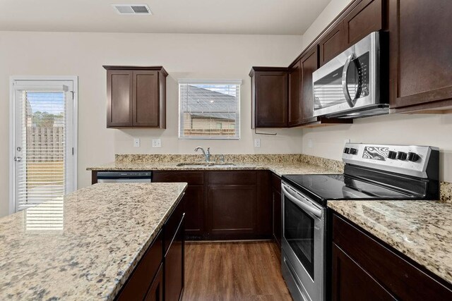 kitchen with stainless steel appliances, a wealth of natural light, sink, and dark hardwood / wood-style flooring