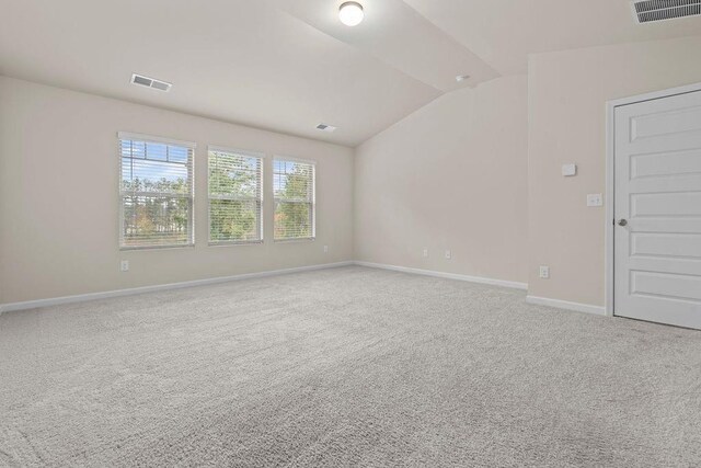 carpeted empty room featuring lofted ceiling