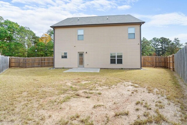 back of house featuring a lawn and a patio