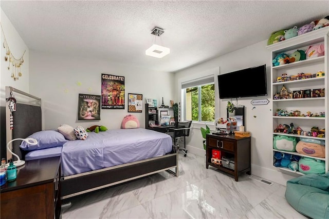 bedroom with light tile patterned flooring and a textured ceiling