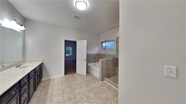 full bath featuring a shower stall, vanity, baseboards, visible vents, and a garden tub