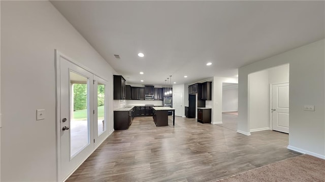 unfurnished living room with recessed lighting, visible vents, wood finished floors, and baseboards