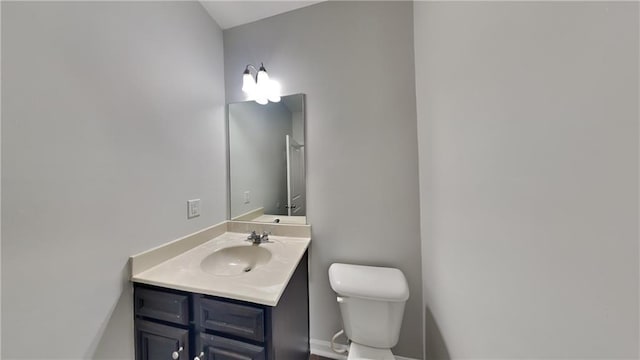 bathroom with vanity, toilet, and baseboards