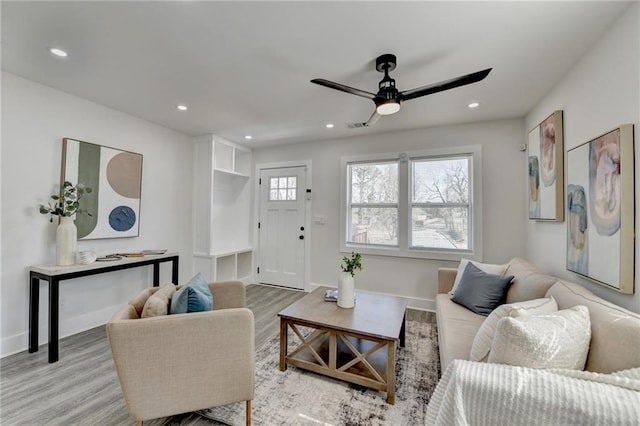 living area with light wood-style flooring, baseboards, and recessed lighting