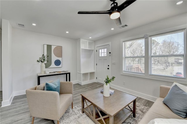 living room featuring recessed lighting, visible vents, baseboards, and wood finished floors