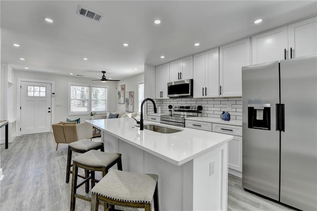 kitchen with light countertops, appliances with stainless steel finishes, a sink, and visible vents