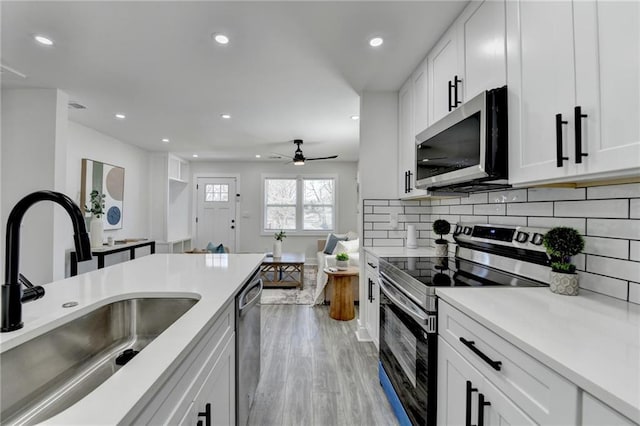 kitchen featuring light countertops, appliances with stainless steel finishes, a sink, and white cabinetry