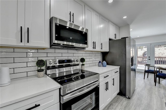 kitchen with stainless steel appliances, light countertops, and white cabinets