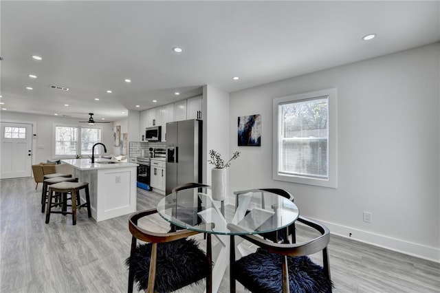 dining area with light wood-style floors, recessed lighting, visible vents, and plenty of natural light