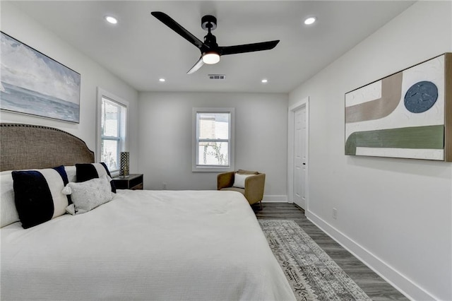 bedroom with baseboards, visible vents, dark wood finished floors, and recessed lighting