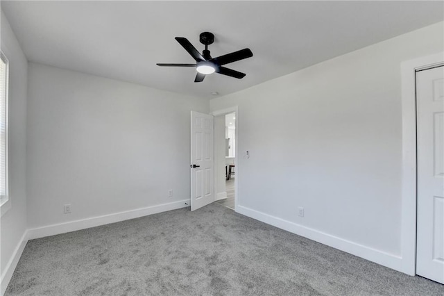 unfurnished bedroom featuring light carpet, a ceiling fan, and baseboards