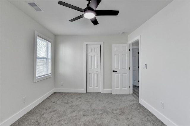 unfurnished bedroom with light colored carpet, a closet, visible vents, and baseboards