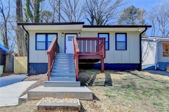 view of front of home featuring board and batten siding and fence