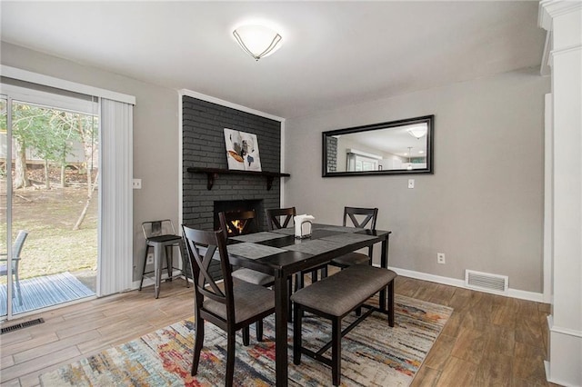 dining room with a fireplace and hardwood / wood-style floors