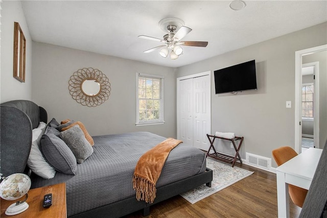 bedroom featuring a closet, dark hardwood / wood-style floors, and ceiling fan